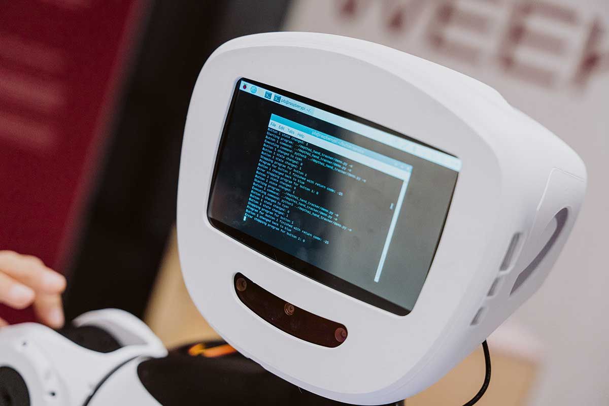 Nahaufnahme des Kopfes des Roboters pib, dessen Display eine Textkonsole zeigt