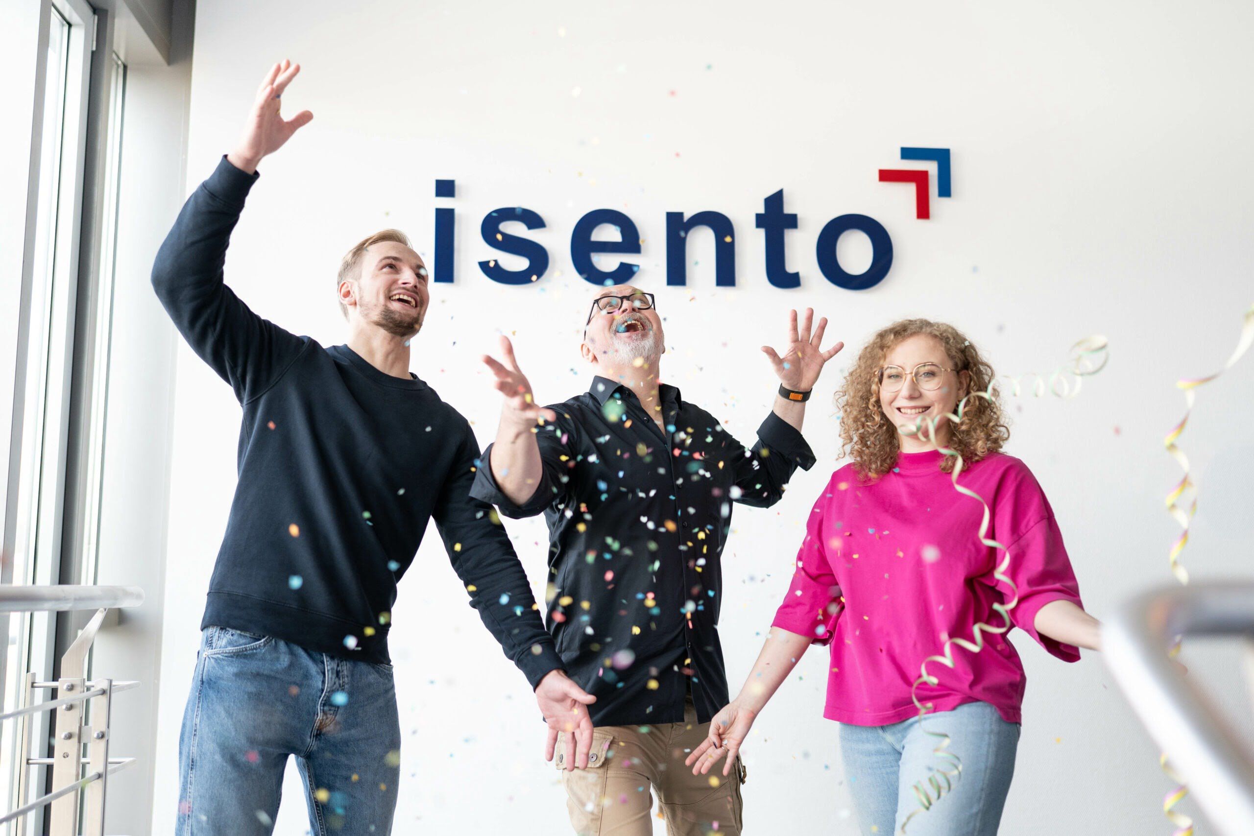 Mitarbeitende von isento feiern gemeinsam mit Konfetti